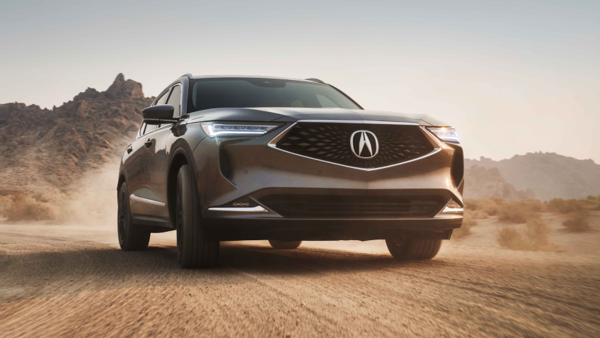 3/4 view of champagne-coloured MDX on desert road.