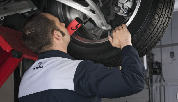 Gros plan d’un technicien Acura qui inspecte le frein à disque d’une Acura.