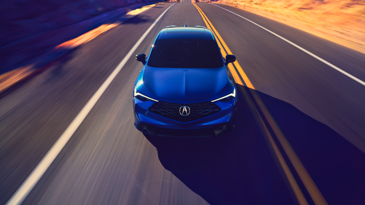 Front shot of an Acura ADX on a highways with blue graphcis emenating from the front grille.