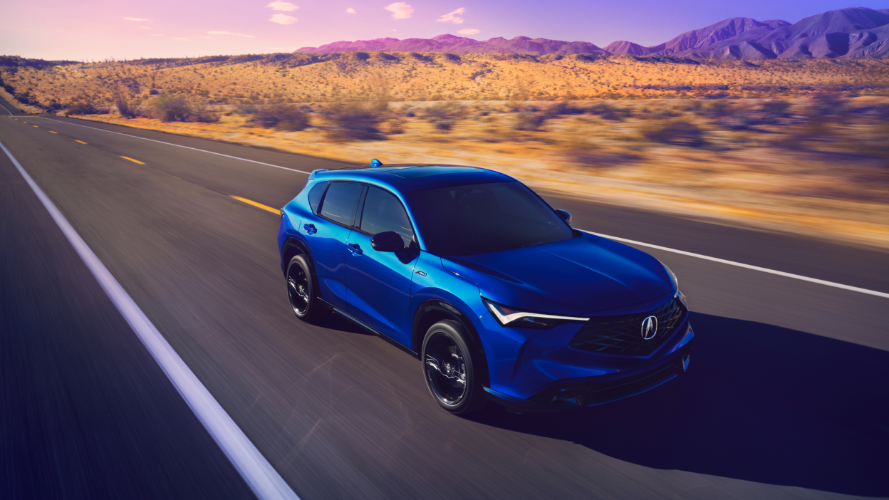 Medium shot of blue Acura ADX on a desert highyway.