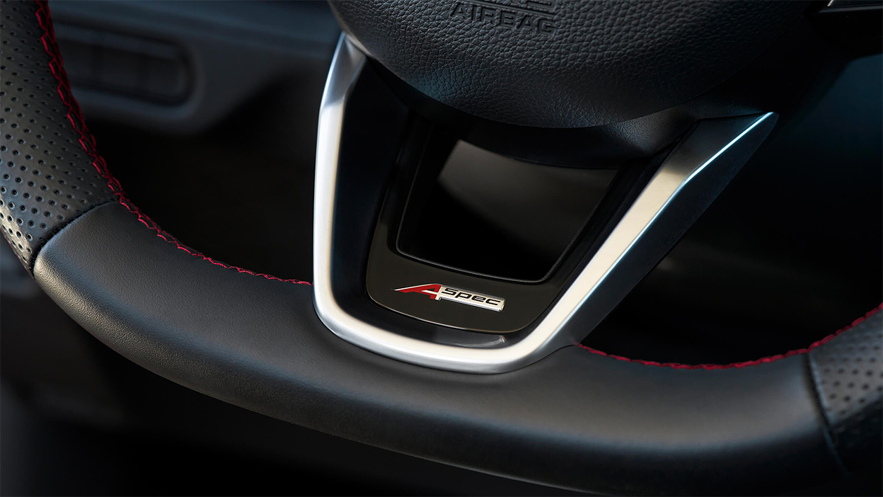 The A-SPEC badge on the bottom of an MDX steering wheel.