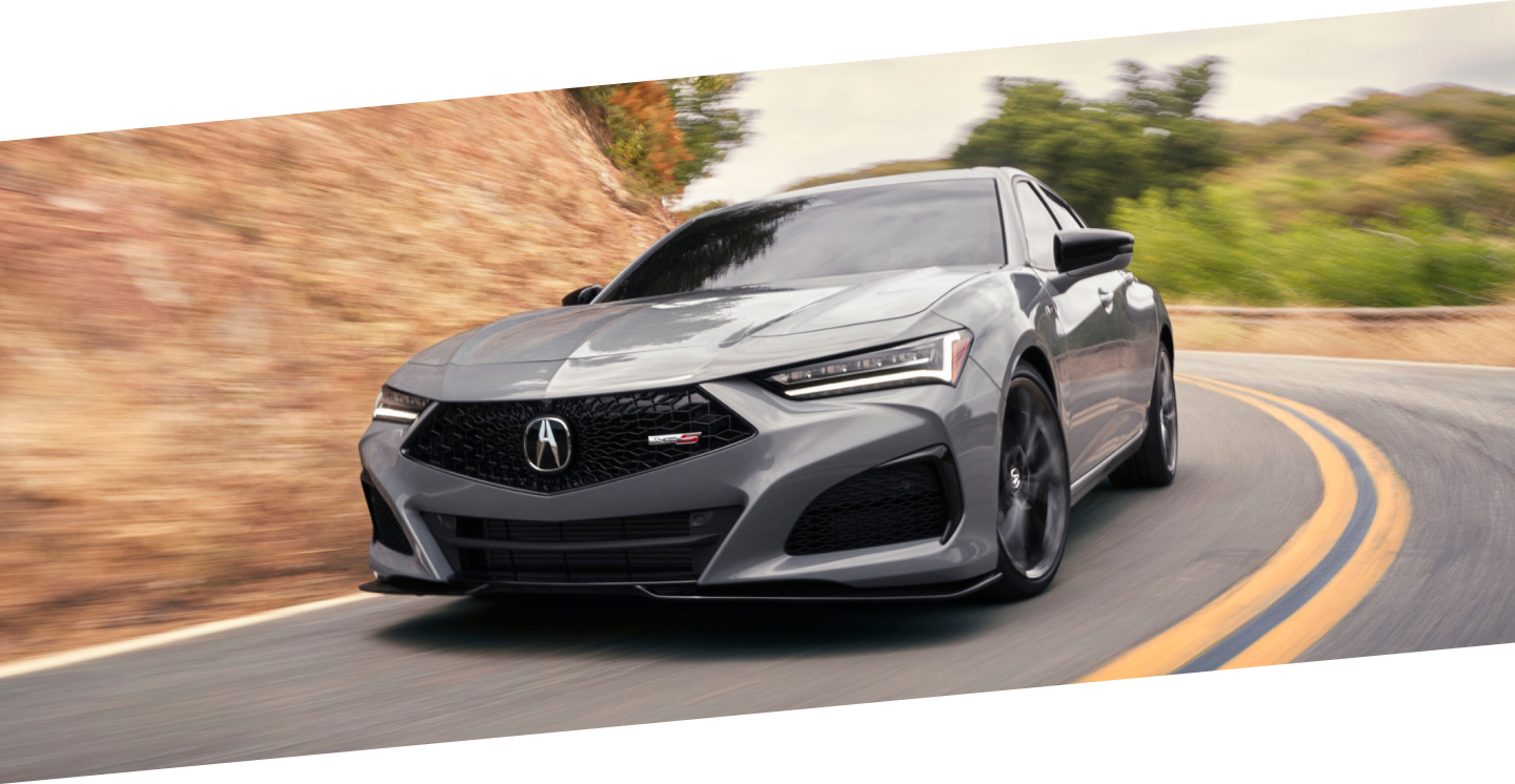 Gros plan avant d’une TLX Type S grise prenant un virage sur l’autoroute.