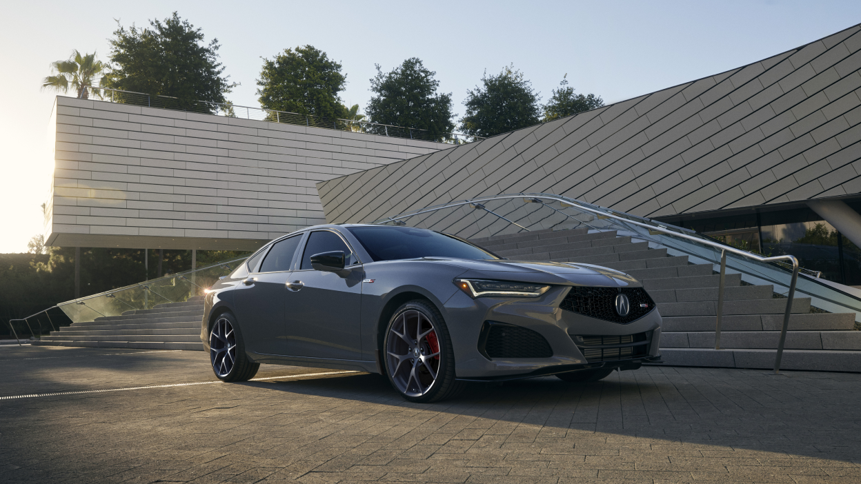 The front wheel of TLX in the foreground. Mountains, clouds and blue sky in the background.