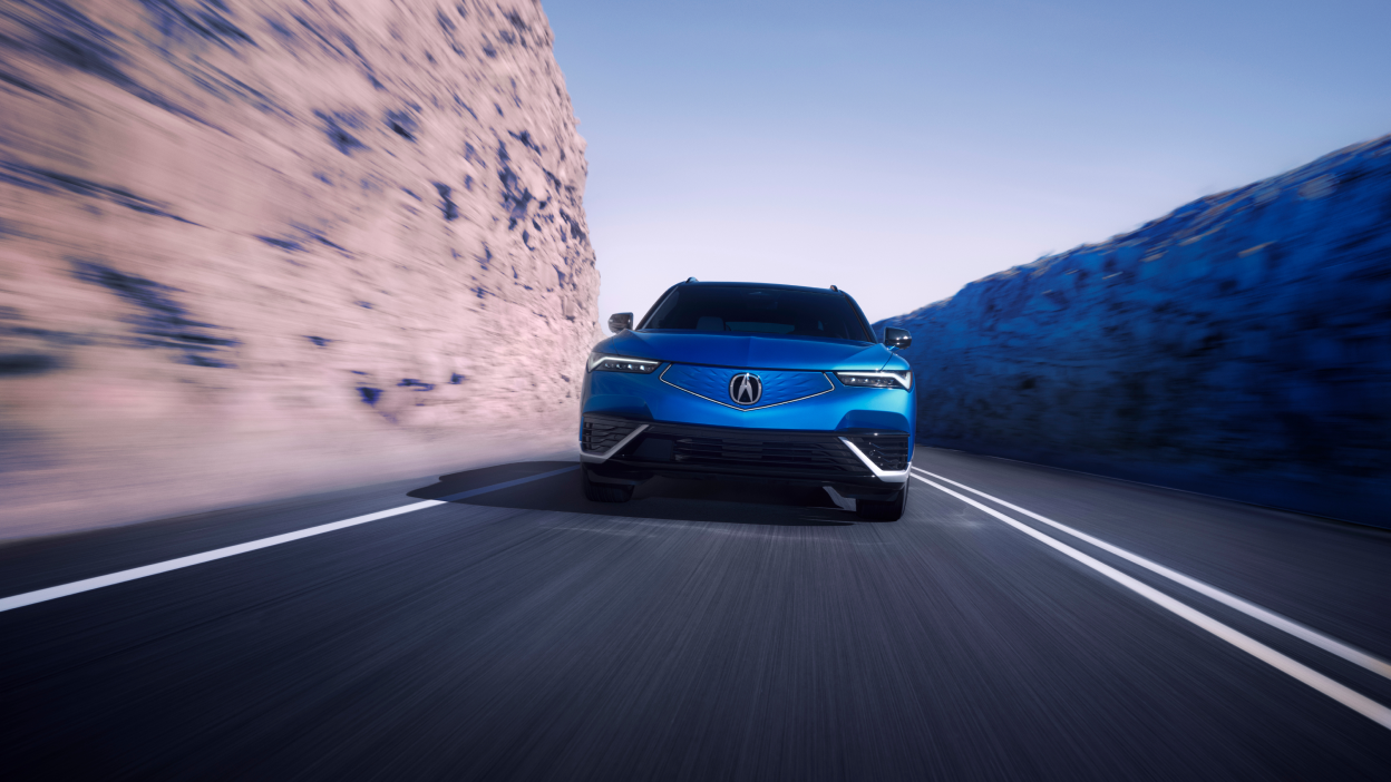 Wide front view of blue ZDX on highway driving toward camera.