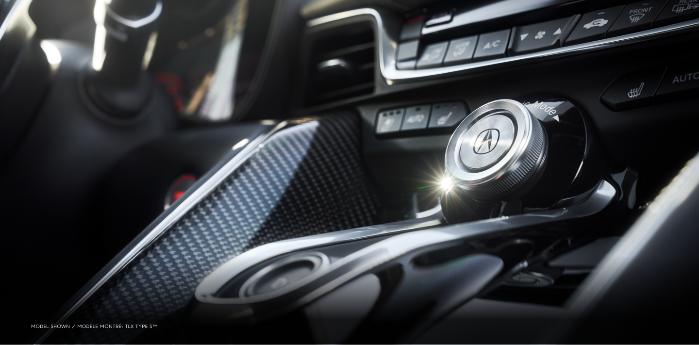 Gros plan des cadrans et boutons de la console centrale avec les éléments décoratifs en fibre de carbone à l’intérieur de la TLX Type S.