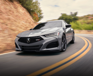Plan avant d’une TLX Type S grise prenant un virage sur l’autoroute.