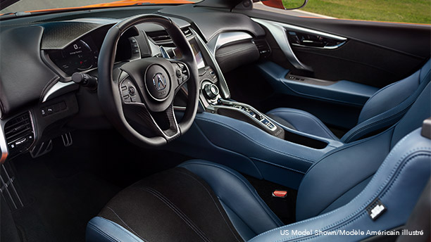 Interior front cabin in an Acura NSX featuring blue and black leather seating. Habitacle avant d’une Acura NSX avec sièges en cuir bleu et noir.